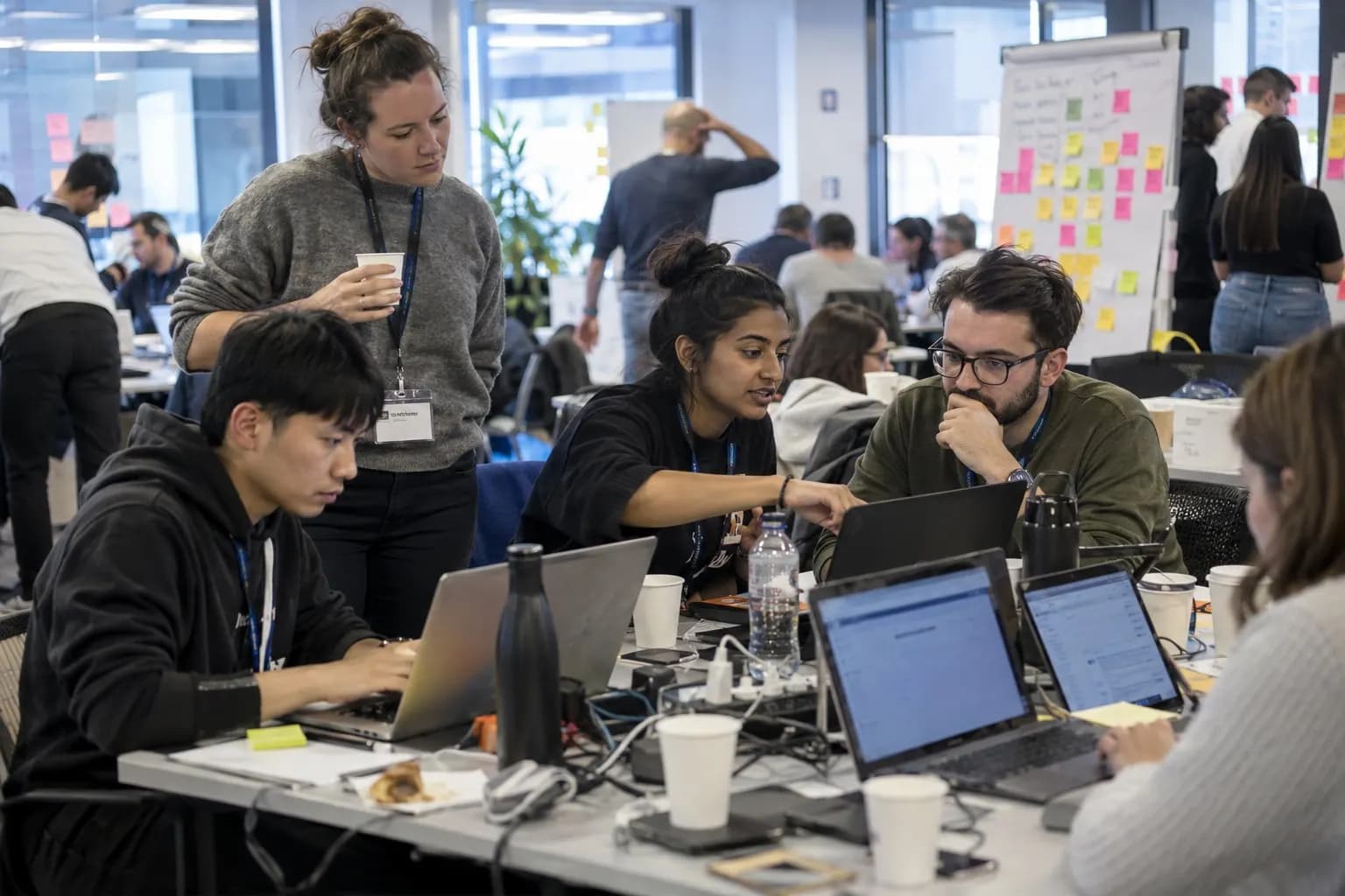 Teams koder på bærbare computere under et virksomhedshackathon